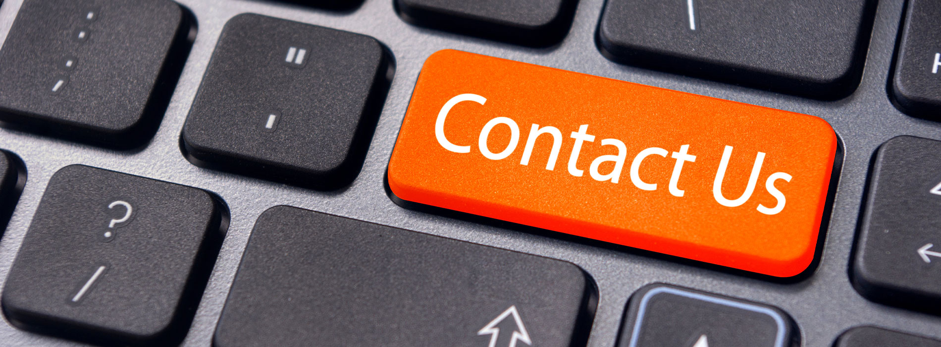 The image shows a computer keyboard with an orange 'contact us' button on top of it.