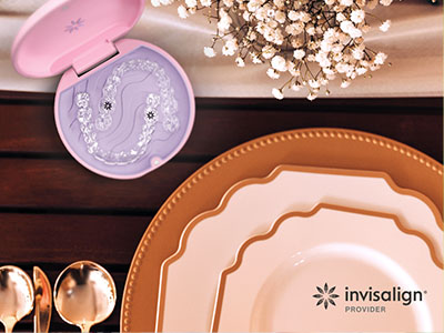 The image shows a collection of tableware, including plates, bowls, and a spoon, displayed on a wooden surface with a pink boxed product in the background, suggesting a setting for showcasing home goods.