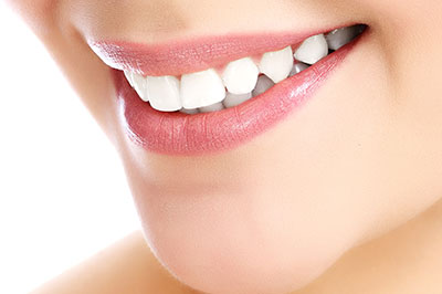 The image shows a close-up of a person's face with a focus on their teeth and lips, highlighting a dental care product or service.
