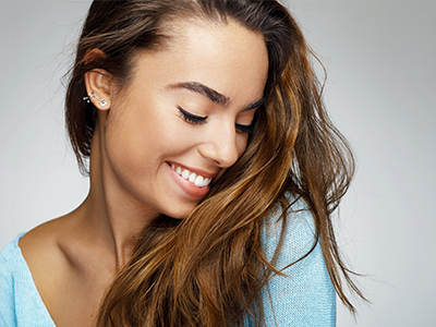 A woman with long hair smiles gently at the camera.